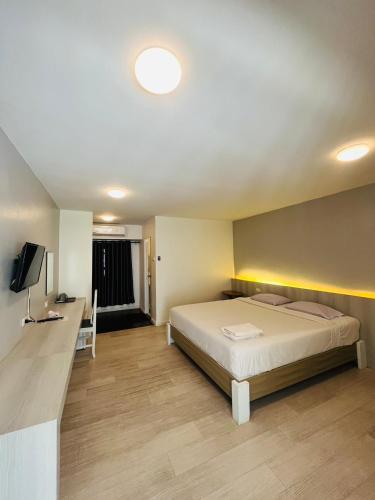a bedroom with a bed and a desk and a television at Kiatnakhon Hotel in Nakhon Si Thammarat
