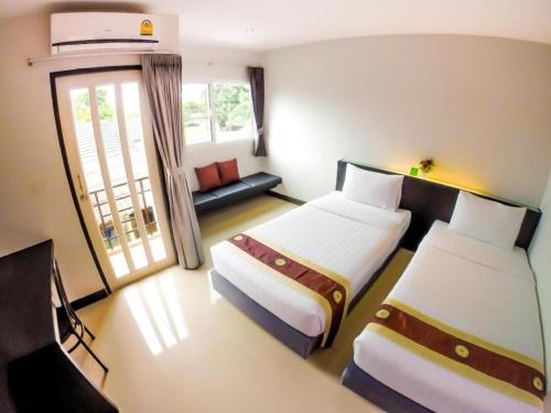 a hotel room with two beds and a couch at My Place Phuket Airport Mansion in Patong Beach