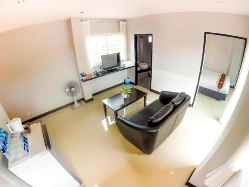 a living room with a black leather couch and a mirror at My Place Phuket Airport Mansion in Patong Beach