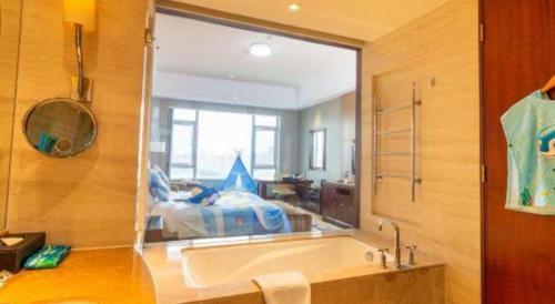 a bathroom with a tub and a large window at Quanzhou Guest House Hotel in Quanzhou