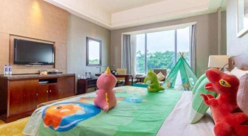a bedroom with stuffed animals sitting on a bed at Quanzhou Guest House Hotel in Quanzhou