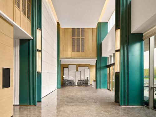 an empty hallway of a building with green columns at Courtyard by Marriott Shunde in Shunde