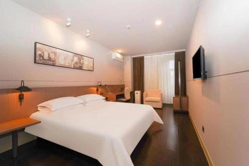 a bedroom with a large white bed and a television at Jinjiang Inn Select Shanghai International Tourism and Resorts Zone Chuansha Road Subway Station in Shanghai