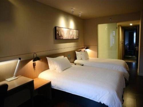 a hotel room with two beds and a desk at Jinjiang Inn Select Shanghai International Tourism and Resorts Zone Chuansha Road Subway Station in Shanghai
