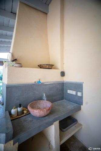 La salle de bains est pourvue d'un lavabo en pierre sur un comptoir. dans l'établissement À Font Aubarne, à Nîmes