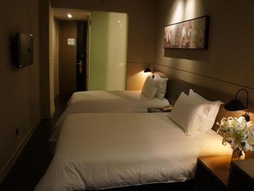 a hotel room with two beds with white pillows at Jinjiang Inn Select Shanghai International Tourism and Resorts Zone Chuansha Road Subway Station in Shanghai