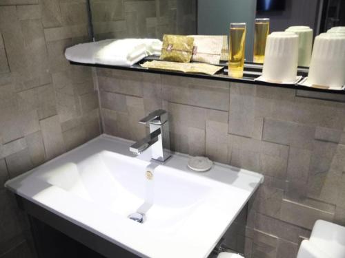 a bathroom with a sink and a counter with drinks at M1 North Point Hotel in Hong Kong