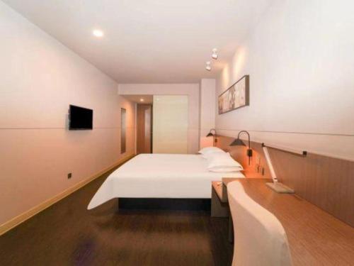a bedroom with a white bed and a tv at Jinjiang Inn Select Shanghai International Tourism and Resorts Zone Chuansha Road Subway Station in Shanghai