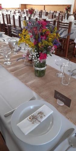 a table with a white table with flowers on it at Resort Ohrada in Vísky