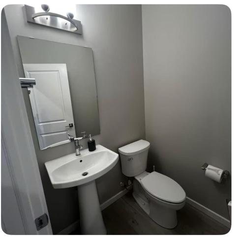 a white bathroom with a toilet and a sink at Bedroom in Southwest 2 in Edmonton