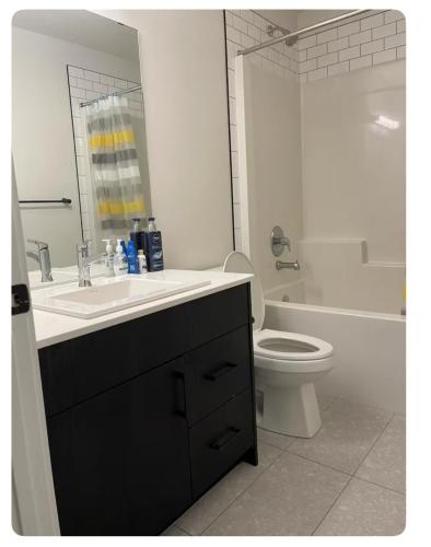 a white bathroom with a sink and a toilet at Bedroom in Southwest 2 in Edmonton