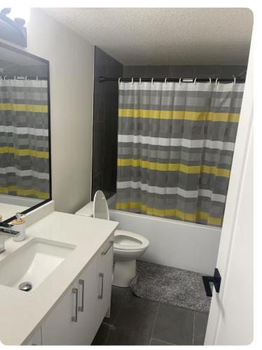 a bathroom with a sink and a shower curtain at Bedroom in Southwest 2 in Edmonton