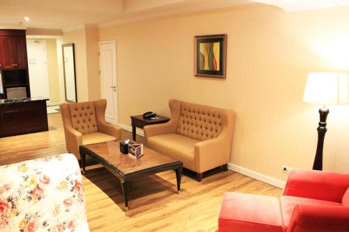 a living room with two chairs and a coffee table at Adimulia Hotel Medan in Medan