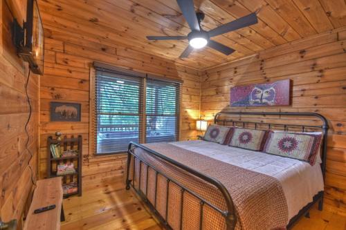 ein Schlafzimmer mit einem Bett in einer Blockhütte in der Unterkunft Bearfoot Ridge Wood-burning fireplace cozy hot tub serene views in Ellijay