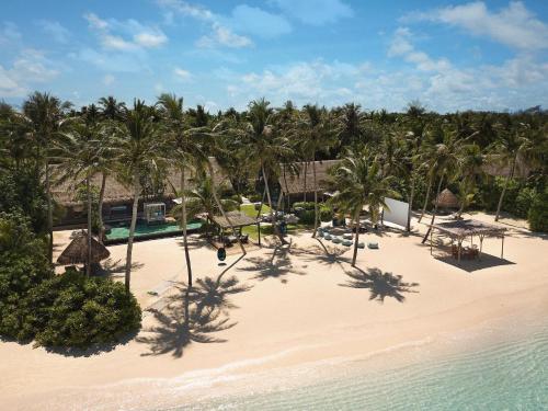 an aerial view of a beach with palm trees at One&Only Reethi Rah in Reethi Rah