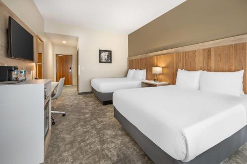 Una habitación de hotel con una cama grande y un escritorio. en Radisson Hotel Pendleton Airport, en Pendleton