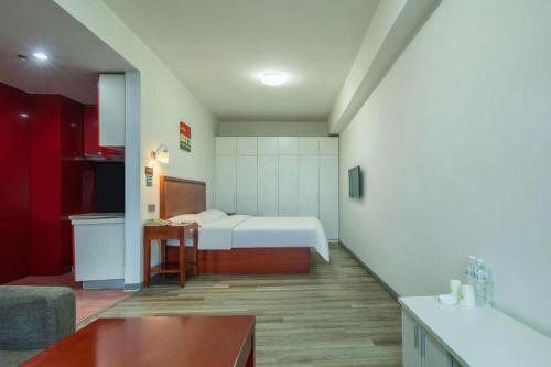 a small room with a bed and a kitchen at GreenTree Inn Weihai Liugongdao Wharf Qingdao North Road Express Hotel in Weihai