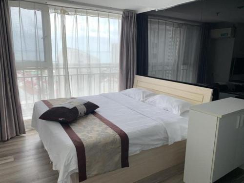 a bedroom with a large bed with a large window at GreenTree Inn Weihai Liugongdao Wharf Qingdao North Road Express Hotel in Weihai