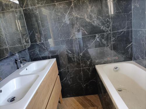 a person taking a picture of a bathroom with a sink and a tub at Maison au calme, proche du centre de Landerneau in Landerneau
