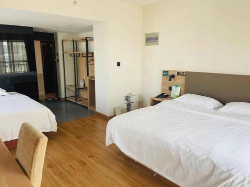 a hotel room with two beds and a chair at GreenTree Inn Weihai Liugongdao Wharf Qingdao North Road Express Hotel in Weihai