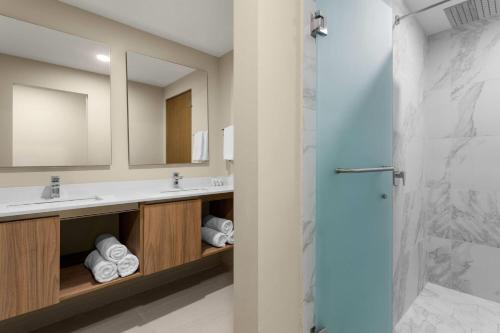 a bathroom with two sinks and a shower at Wyndham Garden Mazatlan Marina in Mazatlán