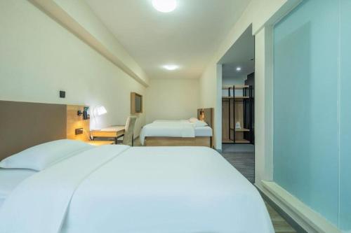 a hotel room with a bed and a bedroom at GreenTree Inn Weihai Liugongdao Wharf Qingdao North Road Express Hotel in Weihai