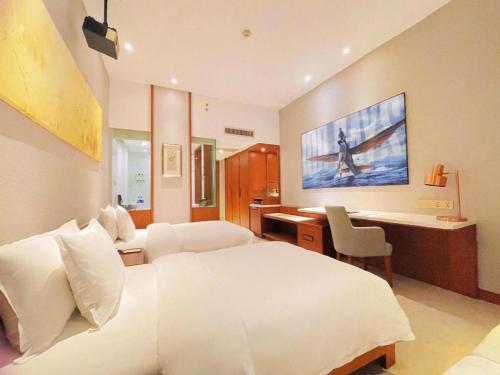 a hotel room with a bed and a desk and a tv at Deacon House Wuxi in Wuxi