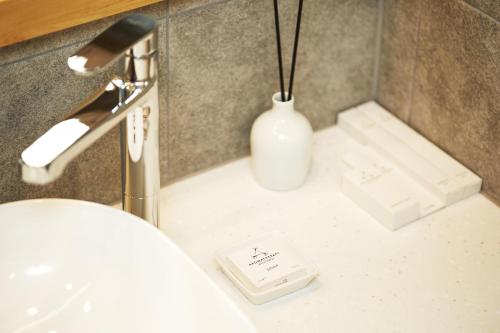 a bathroom with a white bottle of soap and a sink at Bukchon Binkwan by Rakkojae in Seoul