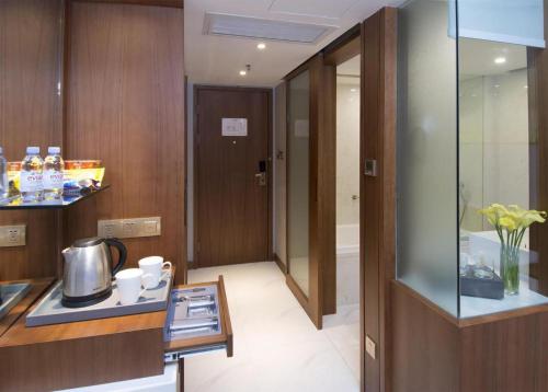 a kitchen with wooden cabinets and a counter with a tea kettle at Deacon House Wuxi in Wuxi