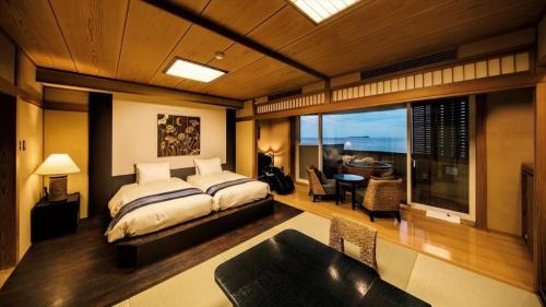 a bedroom with a bed and a living room at Luxury Wa Hotel Kaze No Kaori in Ito