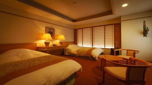 a hotel room with two beds and a window at Shiratamano Yu Kahou in Shibata