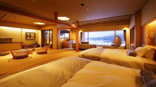 a hotel room with two beds and a large window at Shiratamano Yu Kahou in Shibata