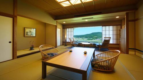 a living room with a wooden table and chairs at Shiratamano Yu Kahou in Shibata