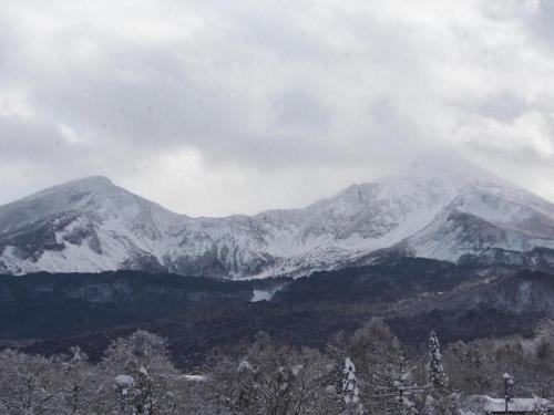 a snow covered mountain with a lake in front of it at Petit Hotel Hoshi no Shizuku in Kitashiobara