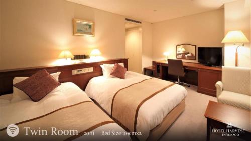 a hotel room with two beds and a desk at Hotel Harvest In Yonago in Yonago