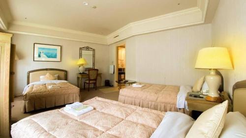 a hotel room with two beds and a couch at Hotel de Premiere Minowa in Inawashiro
