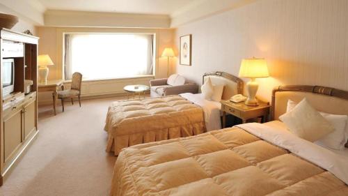 a hotel room with two beds and a television at Hotel de Premiere Minowa in Inawashiro