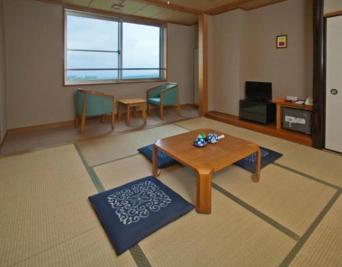 a living room with a wooden table and chairs at Kuju Kogenso Hotel in Kokonoe