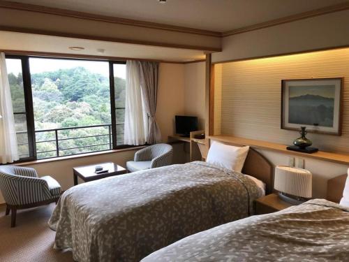 a hotel room with two beds and a window at Shigisan Kanko Hotel in Sango