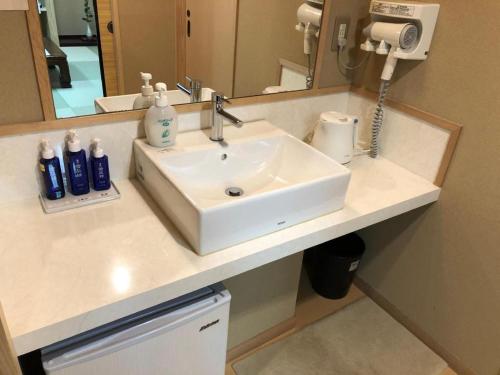 a bathroom with a sink and a mirror at Shigisan Kanko Hotel in Sango