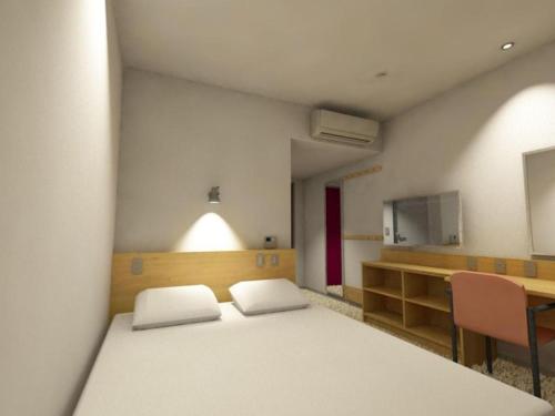 a room with a bed and a desk and a mirror at AKISAWA HOTEL in Shimanto