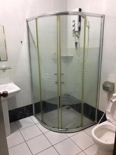 a glass shower in a bathroom with a toilet at Happy Village Kundasang in Ranau