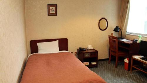 a bedroom with a bed and a desk and a computer at AKISAWA HOTEL in Shimanto