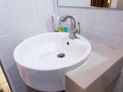 a white sink in a bathroom with a mirror at Champcity Hotel Sdn Bhd in Kuantan