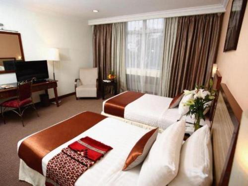a hotel room with two beds and a desk at TH Hotel - Kelana Jaya in Sungai Way