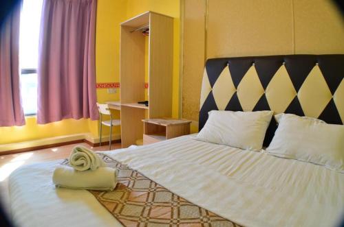 a bedroom with a large white bed with a black headboard at Hotel Zamburger Sungai Besi in Kuala Lumpur