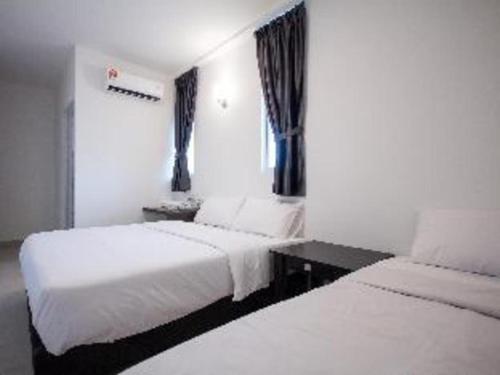a hotel room with two beds and a window at D Nice Hotel in George Town