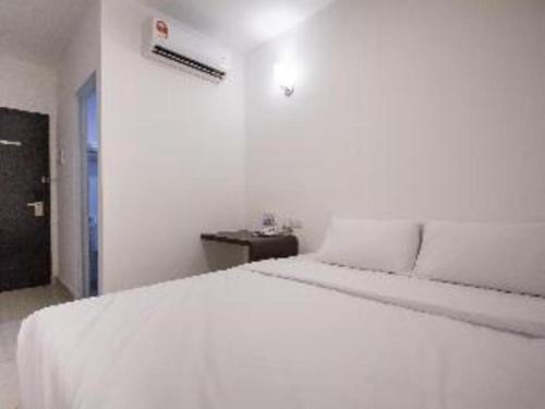 a white bedroom with a white bed in a room at D Nice Hotel in George Town