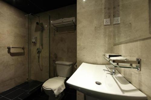 a bathroom with a toilet and a sink and a shower at The Hulo Hotel & Gallery in Kuala Lumpur