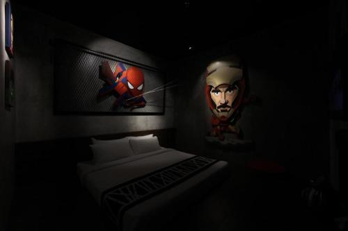 a dark room with a bed and pictures on the wall at The Hulo Hotel & Gallery in Kuala Lumpur
